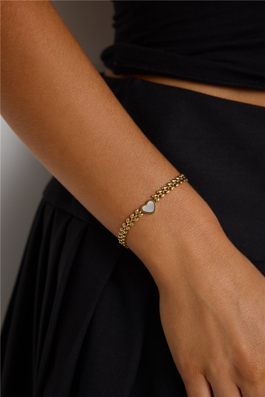 Close-up of a gold bracelet styled with a fashion look