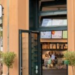 KoRo Café in Berlin mit einer Frau vor dem Eingang
