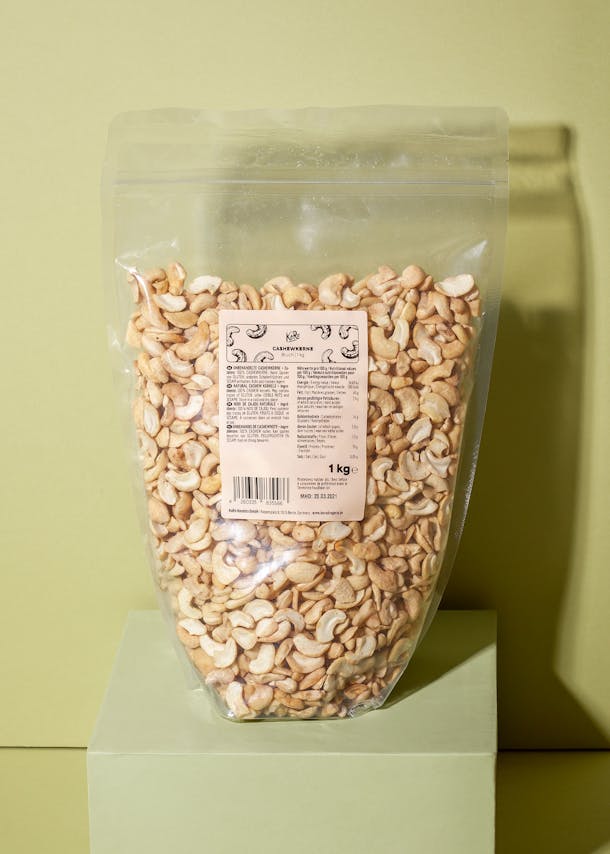 Packung Cashewbruch auf einem grünen Podest