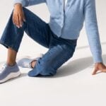 Woman wearing light blue Aetrex sneakers with jeans