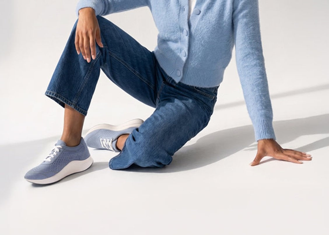 Woman wearing light blue Aetrex sneakers with jeans
