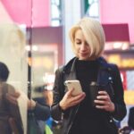 Viajera consultando el móvil durante un viaje con Axa Assistance