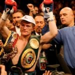 Boxer celebrating with championship belts in a Zapply men's health editorial image