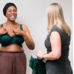 Two women smiling together in a Bravissimo fitting room