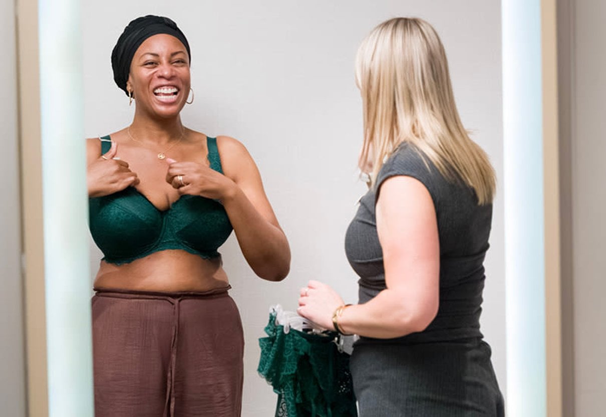 Two women smiling together in a Bravissimo fitting room