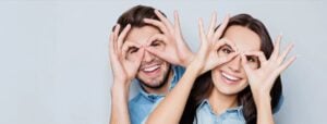 Smiling people making glasses shapes with their hands