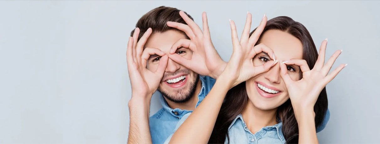 Smiling people making glasses shapes with their hands