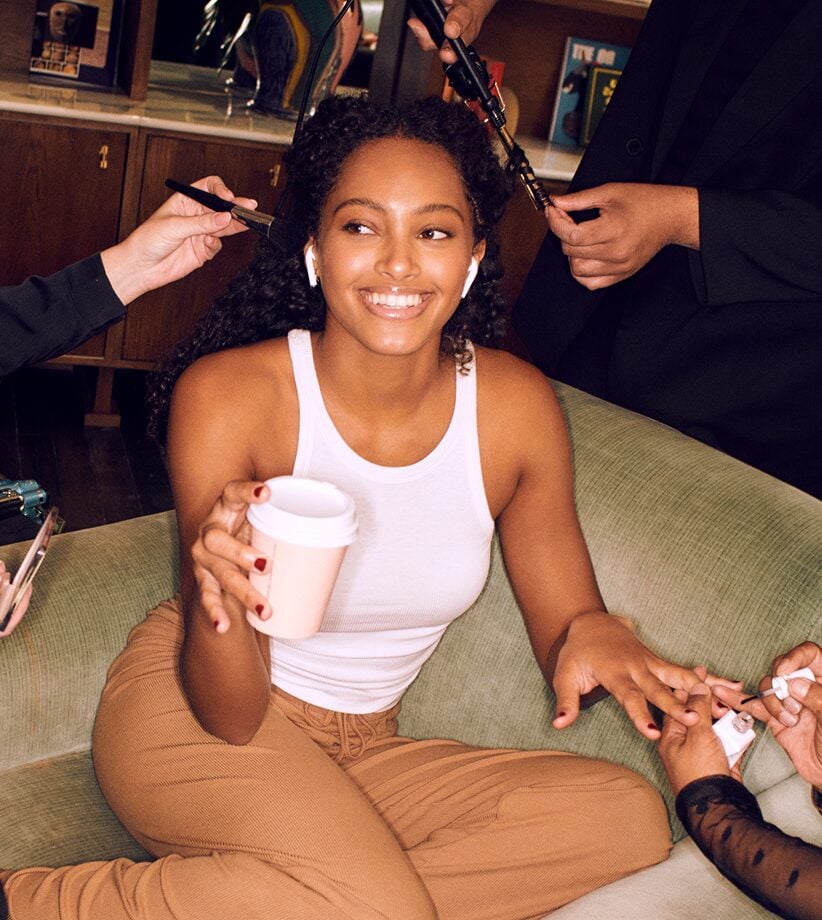 Glamsquad client relaxing at home while pros style her hair and paint her nails