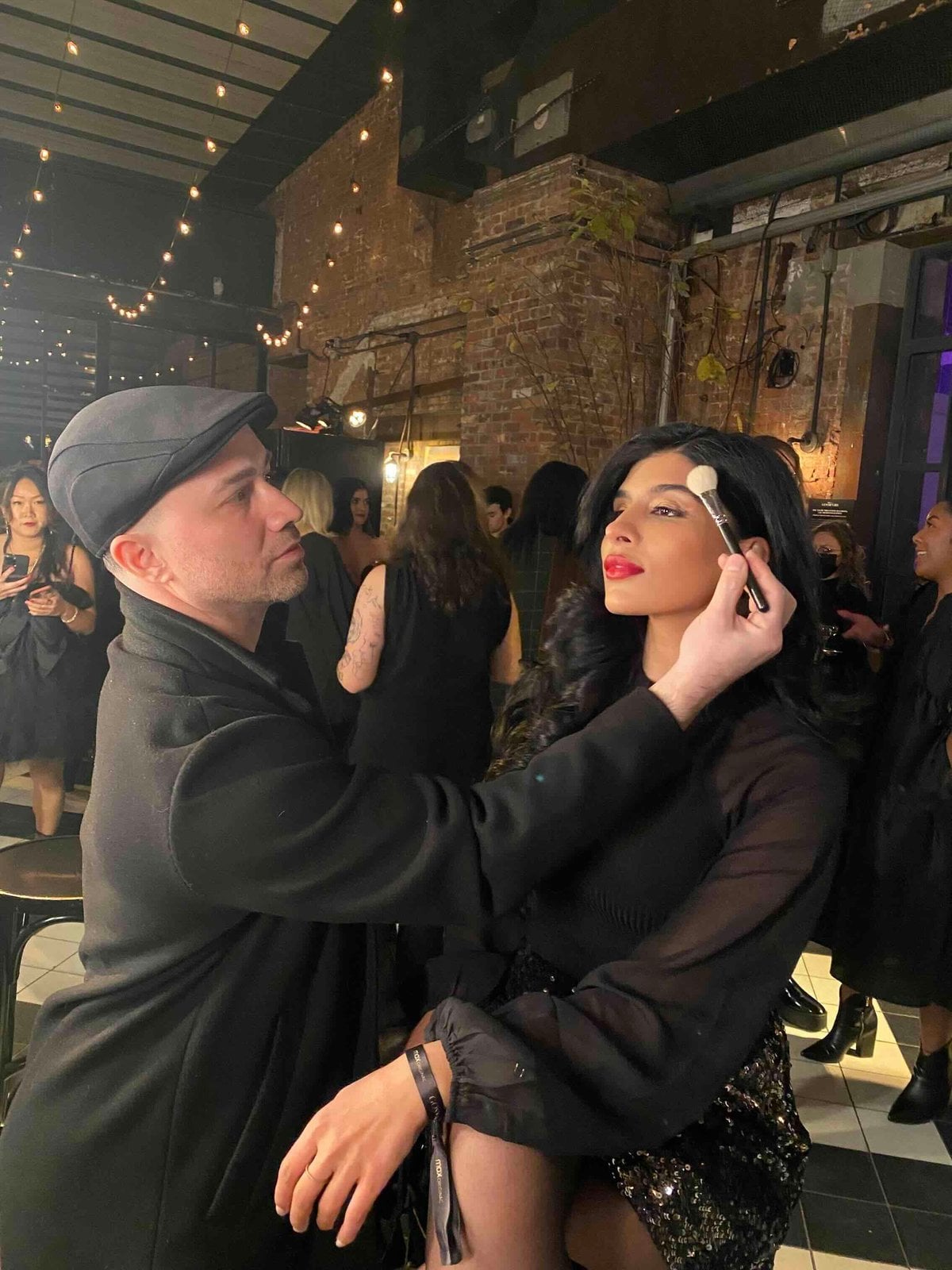 Glamsquad makeup artist applying blush to a guest at an evening event