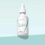 Happy V Liquid Chlorophyll bottle on a colored background