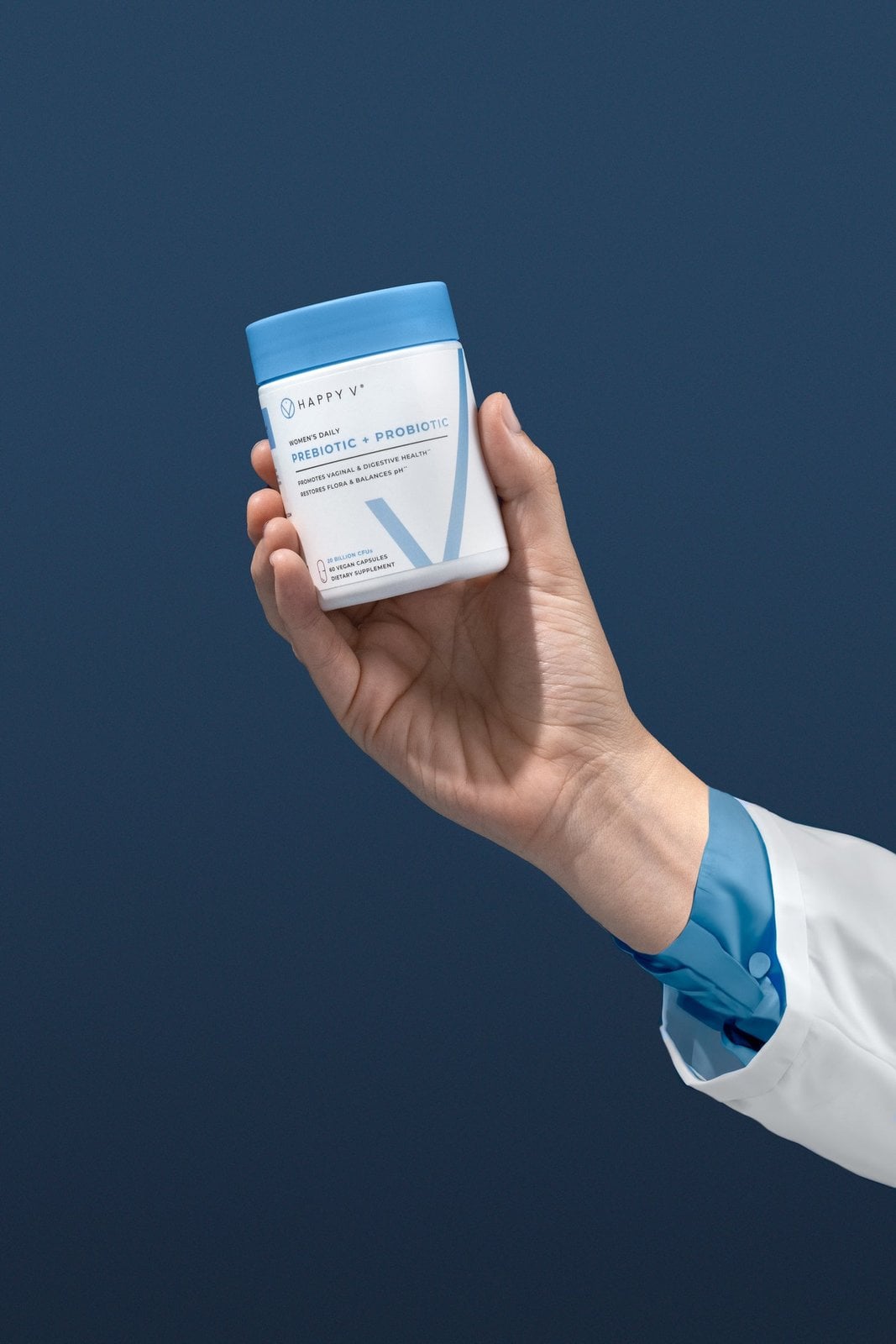 Gloved hand presenting a Happy V Prebiotic + Probiotic jar
