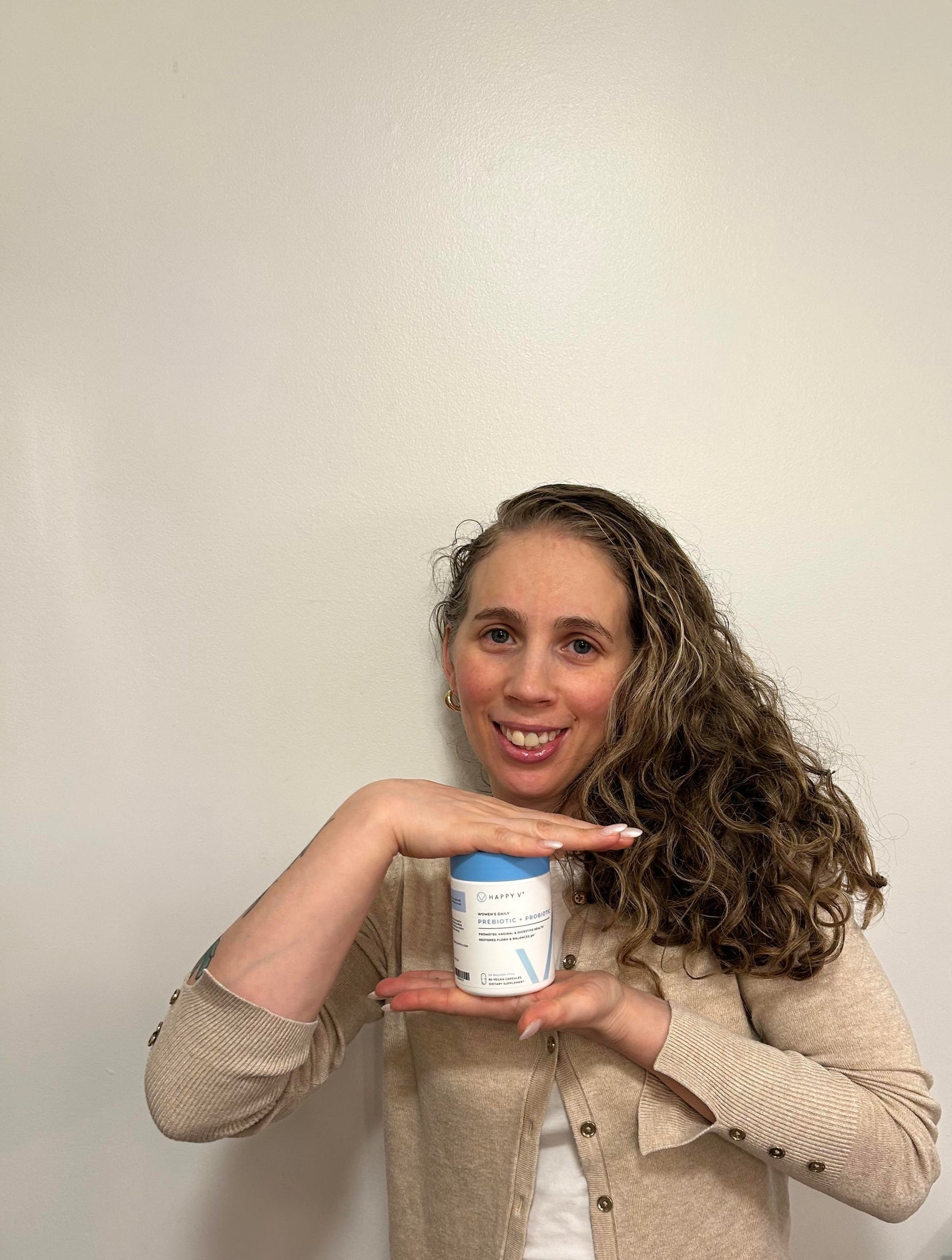 Woman holding a Happy V Prebiotic + Probiotic bottle