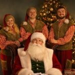 Father Christmas greeting a family inside a festive grotto
