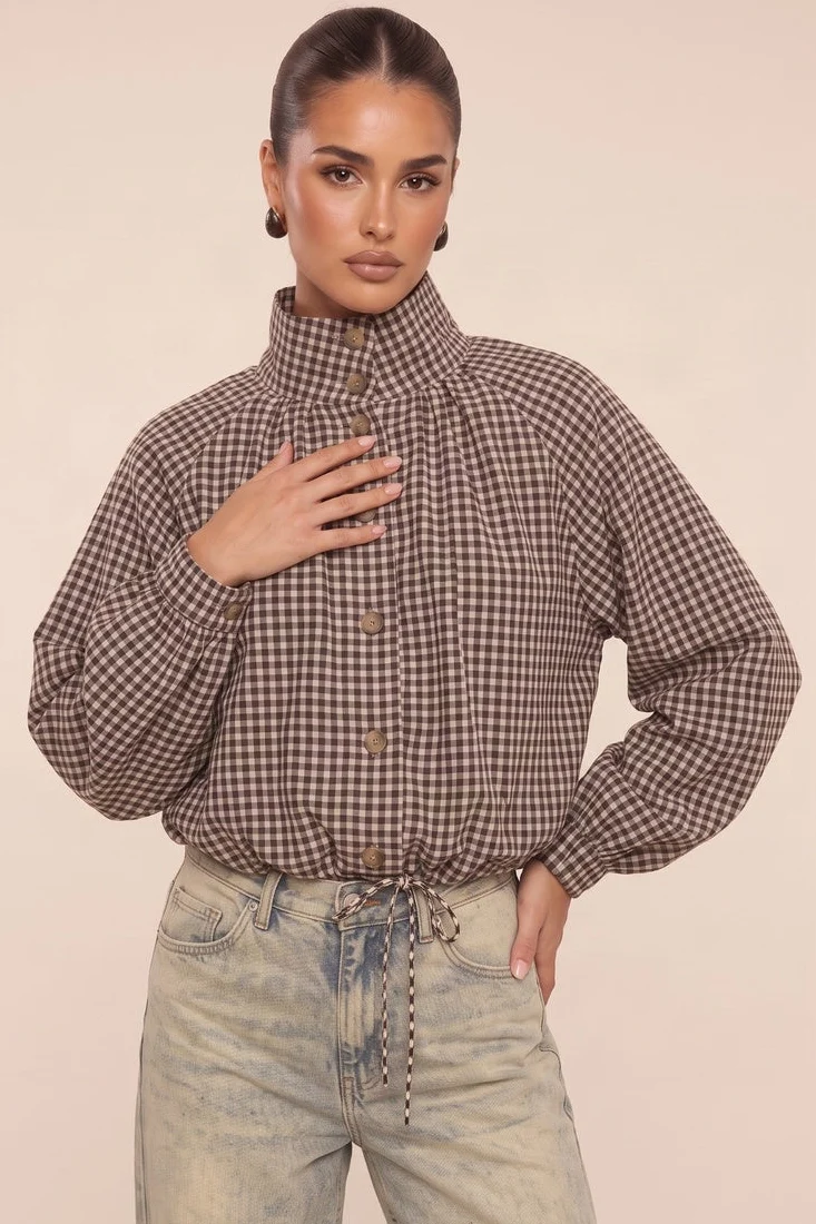 Model wearing a chocolate check funnel neck bomber jacket