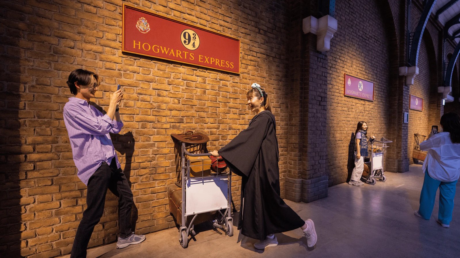 Visitors looking at the Hogwarts Express wall inside the Studio Tour