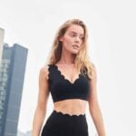 Model wearing black 7/8 high-waist leggings with scalloped trim